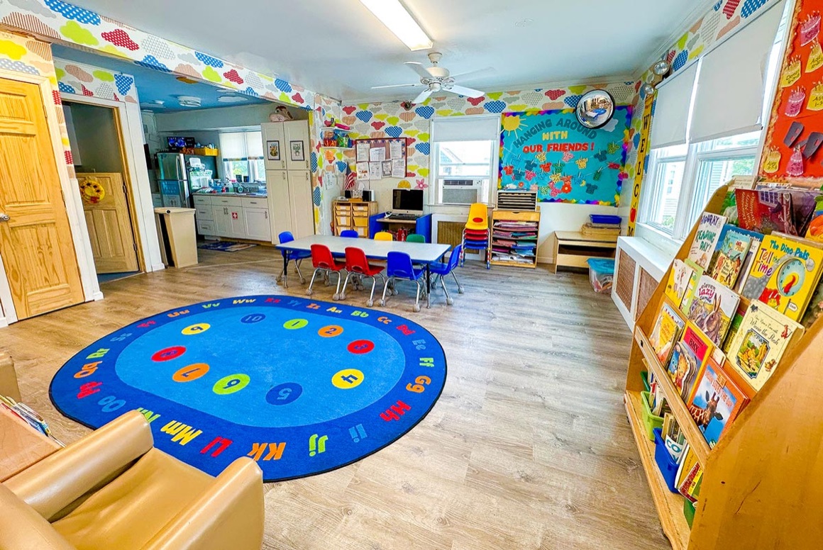 A Pine Tree classroom with an alphabet rug, group table, and a book display
